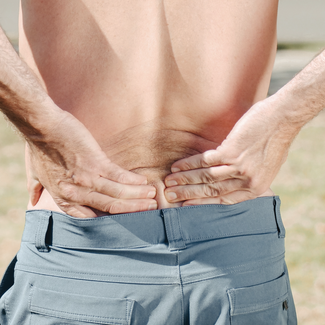 man's back with no shirt, holding in pain