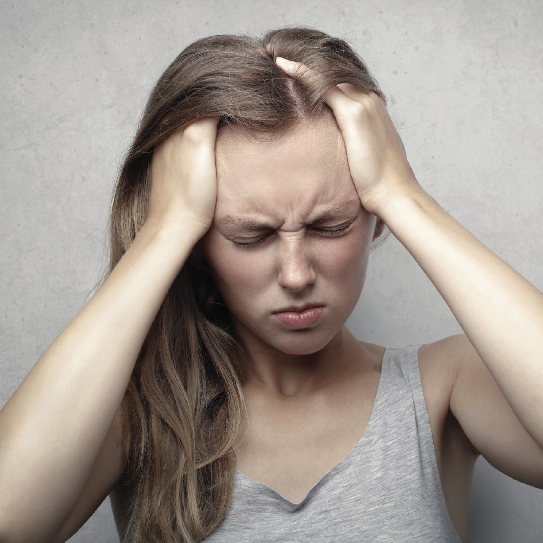 woman holding her head in pain
